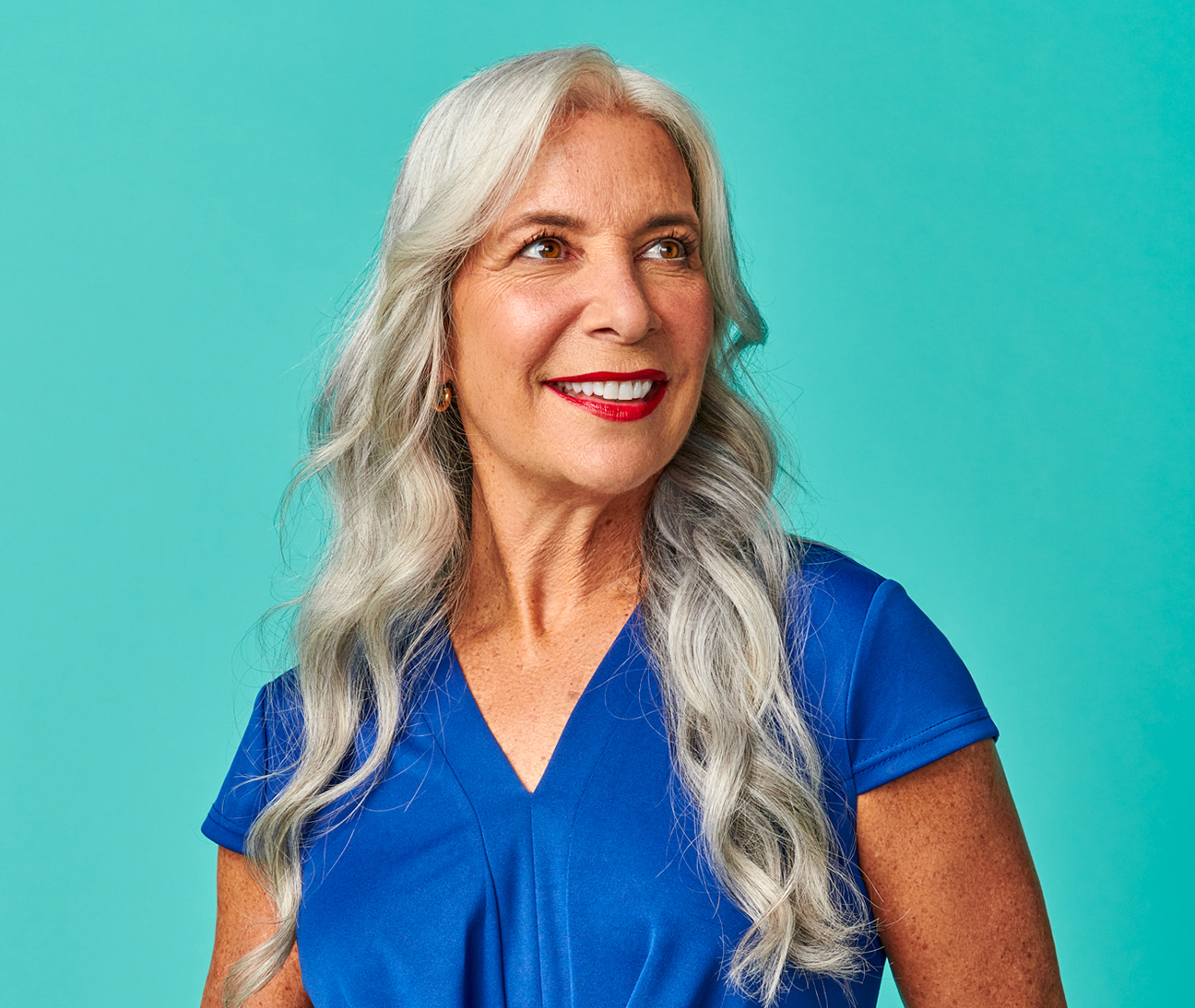 Woman with long white hair and blue scrubs.